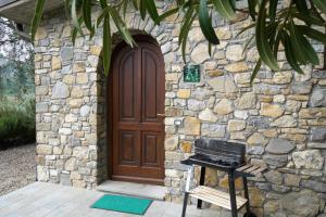 una casa in pietra con una porta in legno e una griglia di U Ciousu by Ligurian Life APPARTAMENTI IN AGRITURISMO a Vallebona Altre 37 foto