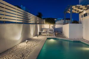 a swimming pool in the backyard of a house at night at Pebble Summer House in Kampos Paros