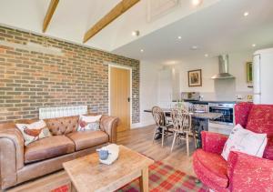 a living room with a couch and a brick wall at 2 Hilltop Cottages in Stansted