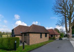 a brick house with a brown roof at 2 Hilltop Cottages in Stansted