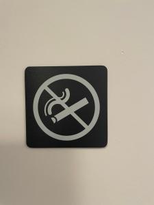 un cartello su un muro con un cartello di divieto di fumo di Catalogna10 Rooms ad Alghero