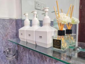 a counter with four bottles of soap and flowers on it at Boho Garden Guest House in Mirissa