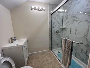 卡內奧赫的住宿－Cozy Custom Vacation Home，带淋浴、卫生间和盥洗盆的浴室