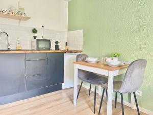 a kitchen with a table and two chairs and a microwave at Le Mélusine , à 50m de la gare de Poitiers in Poitiers