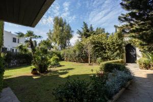a garden with trees and grass and a building at Seaside Apartment with 3 bdrm and Shared Pool! in Athens