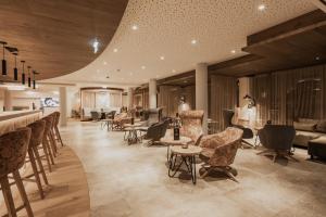 a lobby with chairs and tables and a bar at FIRSTpeak Zauchensee in Zauchensee