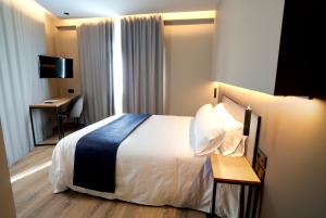una camera d'albergo con letto e scrivania di HOTEL RIO LEA 