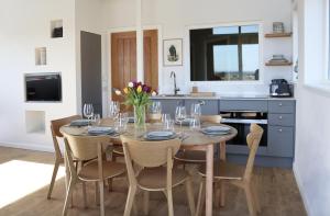 a dining room with a table and chairs and a kitchen at Coastal Eco-Lodge with hottub Charleton Estate in Elie