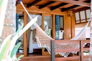 a hammock on the porch of a house at Island View Bar & Bungalow in Gili Islands