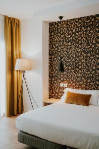 a bedroom with a bed and a wall with a pattern at Rincon 13 - Mares in Torre del Mar