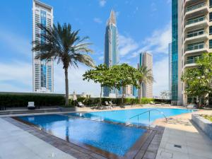 a swimming pool in a city with tall buildings at Ultima Vacation Homes loft 1 BR Apartment in Dubai