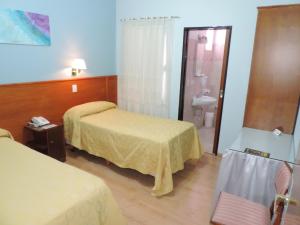 a hotel room with two beds and a bathroom at Hotel Galicia in Trelew +12 photos