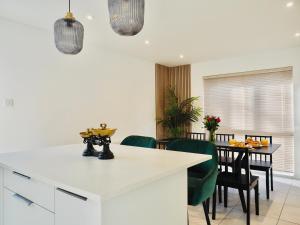 a kitchen and dining room with a table and chairs at Luxurious Detached Bungalow with Private Parking in Farnborough