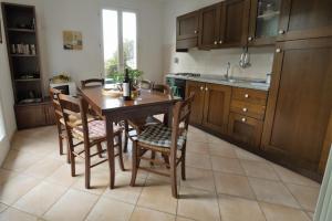 una cucina con tavolo e sedie in legno di U Ciousu by Ligurian Life APPARTAMENTI IN AGRITURISMO a Vallebona