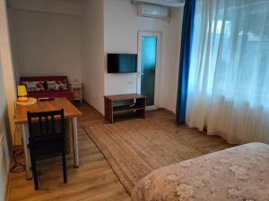 a room with a desk and a table and a television at iVAVev Is Us byTheSea Constanta in Constanţa