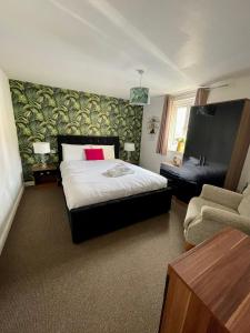 a bedroom with a bed and a couch and a chair at Empire Serviced Apartments in Hinckley