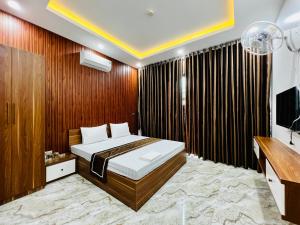 a bedroom with a bed and a television in it at THÀNH HỒNG HOTEL in Ha Tinh
