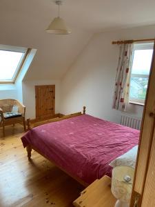 a bedroom with a large bed with a purple blanket at The Cliffs of Moher House, Doolin in Droíchead an Chláir