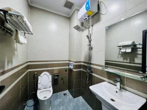 ein Badezimmer mit einem Waschbecken, einem WC und einem Spiegel in der Unterkunft THÀNH HỒNG HOTEL in Provinz Hà Tĩnh