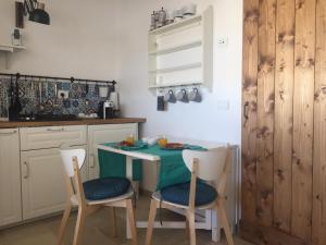 una cocina con una mesa pequeña y sillas. en RIFUGIO Salentro, en Botrugno