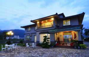 a house with tables and chairs in front of it at Yunju House in Jiaoxi