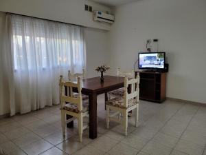 a dining room table with chairs and a television at "La Irma" - Complejo de Departamentos in Lincoln