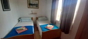twee bedden in een kleine kamer met een raam bij Apartment Bougainvillea in Trogir