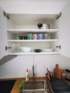 un lavello da cucina con ripiani bianchi sopra di Oxygen studio a Jupiter Altre 11 foto