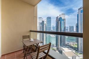 a balcony with a table and chairs and a view of the city at JBR Beach Bliss - One & Three Bedroom Luxury Apartments by Sojo Stay in Dubai