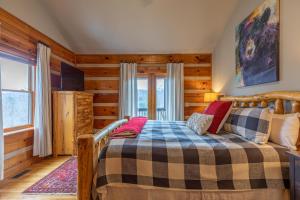 - une chambre avec un lit dans une pièce dotée de murs en bois dans l'établissement River Daze, à Boone