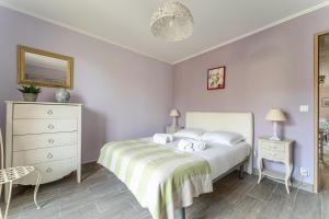 a bedroom with a bed and a dresser and a mirror at Le Mesnil - 200m des plages in Arcachon