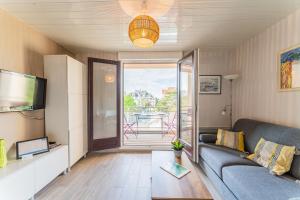 a living room with a couch and a television at Le Mesnil - 200m des plages in Arcachon