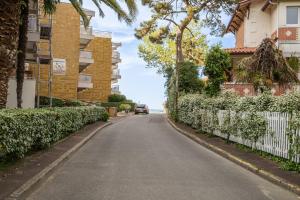 a car driving down a street next to houses at Le Mesnil - 200m des plages in Arcachon