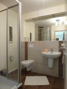 ein Badezimmer mit Toilette und Waschbecken in der Unterkunft Family Apartments Tom in Ostseebad Karlshagen