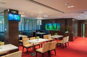 a restaurant with tables and chairs and fish tanks on the wall at Hotel Dream in Sofia