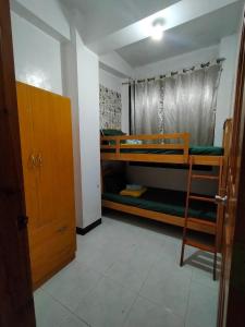een kamer met 2 stapelbedden en een deur bij GH Apartelles in Baguio