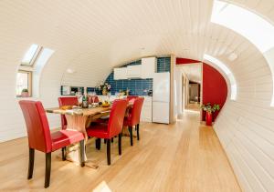 une cuisine et une salle à manger avec une table et des chaises rouges dans l'établissement Bumble Barn, à Lyminge
