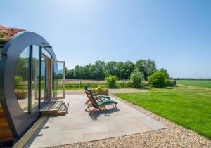 a patio with two chairs and a table in a yard at Bumble Barn in Lyminge