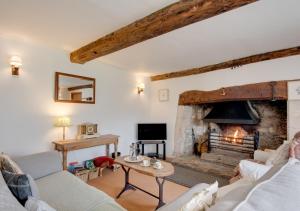 a living room with a fireplace and a couch at Carters Cottage in Slaughterford
