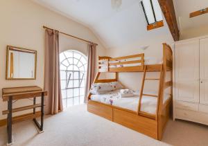 a bedroom with two bunk beds and a window at Chapel House in Sandwich