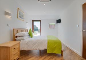 ein Schlafzimmer mit einem Bett mit einer grünen Decke in der Unterkunft Brighton Hopper Hut in Goudhurst