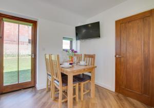 a dining room with a wooden table and chairs at Brighton Hopper Hut in Goudhurst