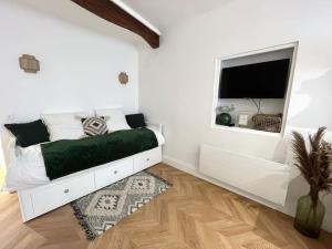 a white bedroom with a bed and a window at Studio Patchouli - Centre historique - Climatisation - WiFi in Grasse