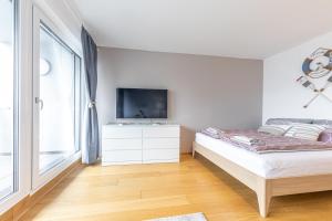 a white bedroom with a bed and a tv at The Splash by JR City Apartments in Vienna +37 photos