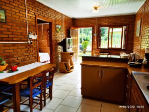 a kitchen with a counter and a table in it at Casa de campo com acesso ao Rio in Encantado