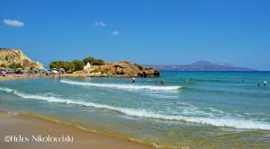 a beach with people swimming in the water at Armonia Apartments in Almirida