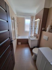 La salle de bains est pourvue de toilettes, d'un lavabo et d'une baignoire. dans l'établissement Sahara Sands LOFT Private Parking, à Timişoara