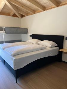 Apartmán Michal في Rattendorf: سرير كبير في غرفة نوم ذات سقف خشبي