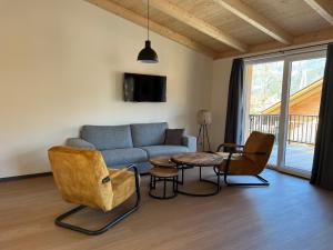 a living room with a couch and a table and chairs at Apartmán Michal in Rattendorf