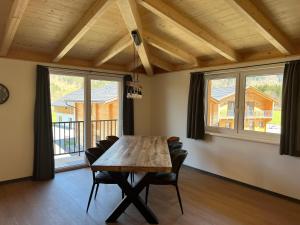 een eetkamer met een houten tafel en stoelen bij Apartmán Michal in Rattendorf